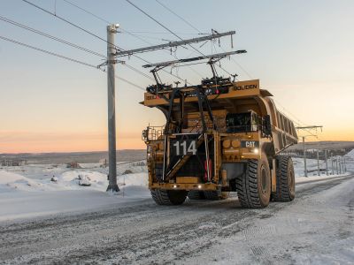 Schwere Muldenkipper hängen sich an die Oberleitung